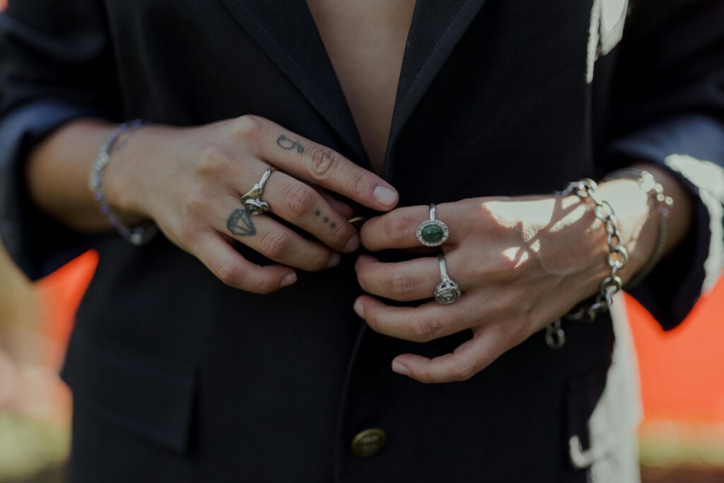 Hands adorned with rings, bracelets, and tattoos, showcasing style and elegance.